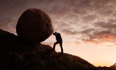 pushing boulder up a mountain